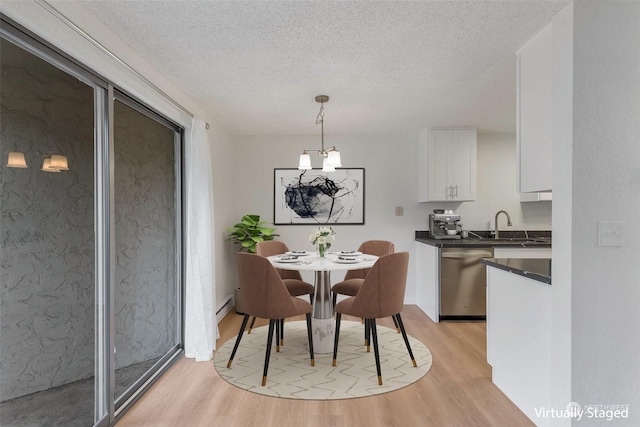 dining space with a textured ceiling and light wood-type flooring