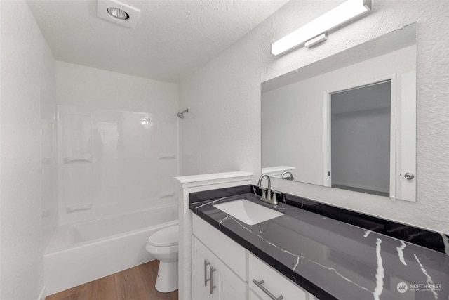 full bathroom featuring shower / bathing tub combination, a textured ceiling, toilet, vanity, and hardwood / wood-style flooring