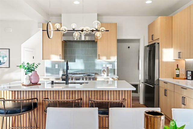 5537 34th Ave NE, Seattle, WA 98105 - kitchen with a breakfast bar, light brown cabinets, backsplash, and stainless steel refrigerator