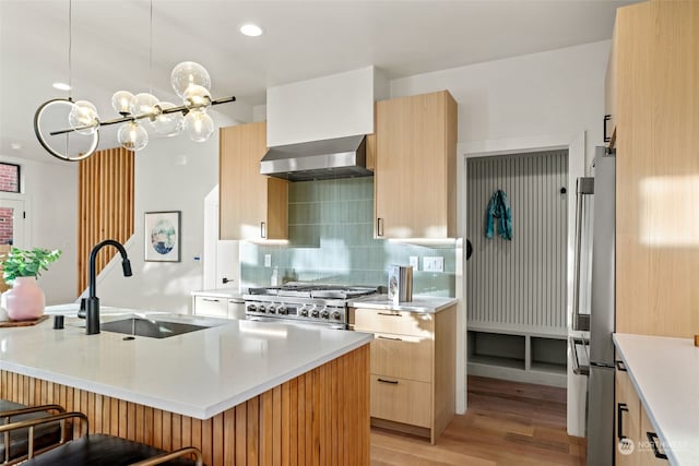 5537 34th Ave NE, Seattle, WA 98105 - kitchen with stainless steel refrigerator, sink, wall chimney range hood, an island with sink, and range