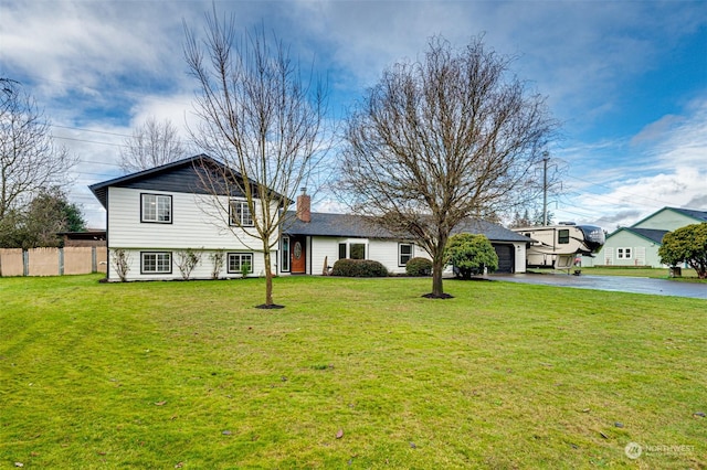 tri-level home featuring a front yard and a garage