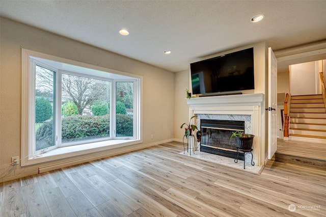 living room featuring light hardwood / wood-style flooring and a premium fireplace