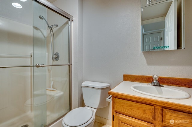 bathroom with vanity, toilet, and an enclosed shower