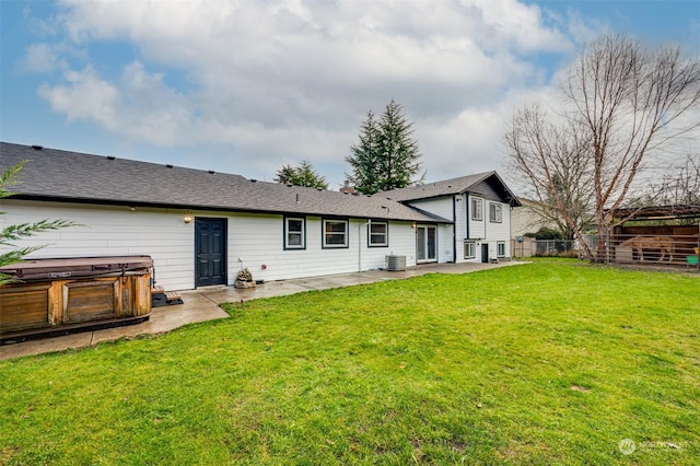 back of house featuring a lawn, cooling unit, a patio area, and a hot tub