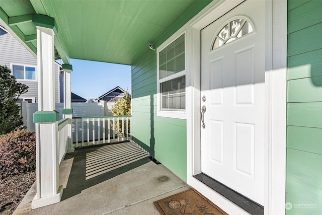 view of exterior entry featuring covered porch