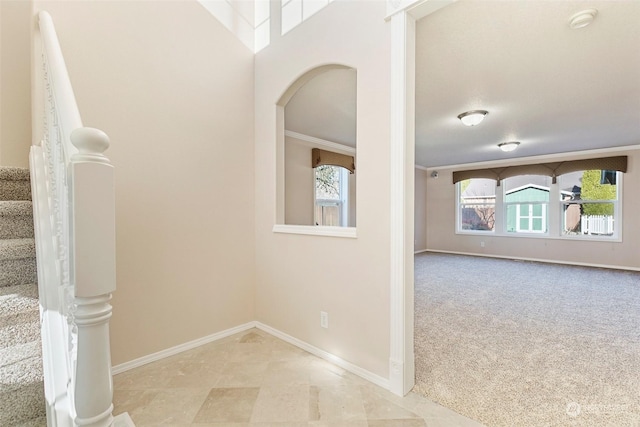 hall featuring light colored carpet and ornamental molding