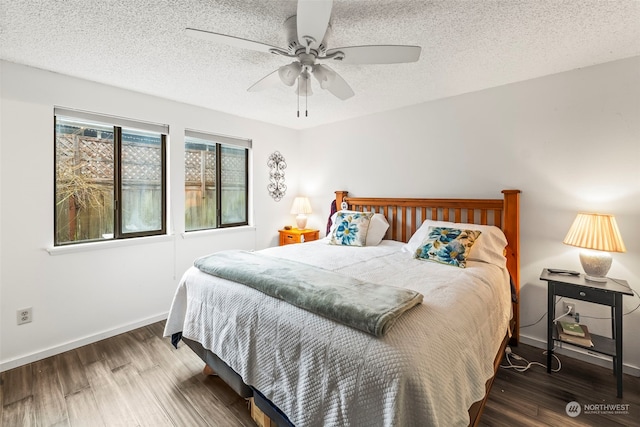 bedroom featuring ceiling fan, dark hardwood / wood-style flooring, and a textured ceiling