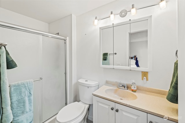 bathroom with vanity, toilet, and a shower with shower door