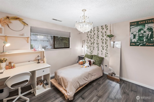 bedroom with a chandelier, a textured ceiling, and dark hardwood / wood-style flooring