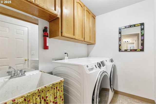 laundry room with cabinets, light tile patterned floors, sink, and washing machine and clothes dryer