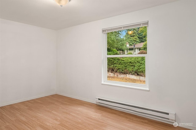 unfurnished room featuring a healthy amount of sunlight, light hardwood / wood-style flooring, and a baseboard radiator