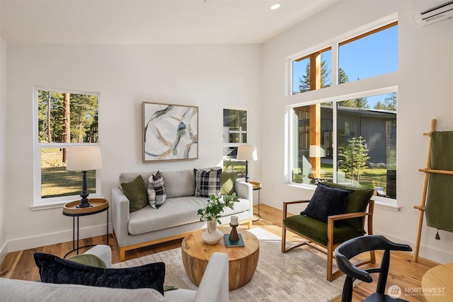 sitting room featuring a wall mounted air conditioner, baseboards, wood finished floors, and recessed lighting