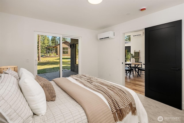bedroom with a wall mounted air conditioner, access to outside, and multiple windows