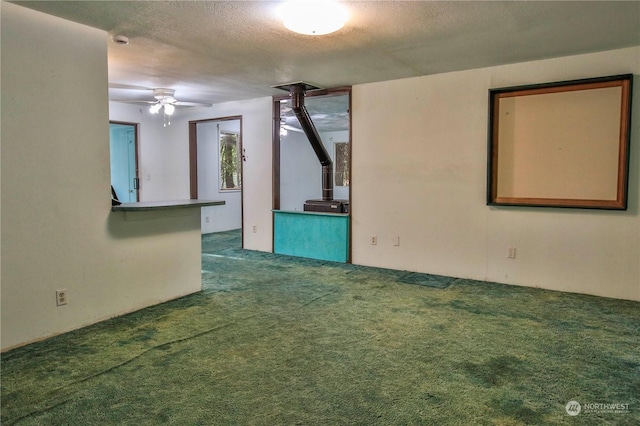 carpeted empty room featuring a textured ceiling and ceiling fan