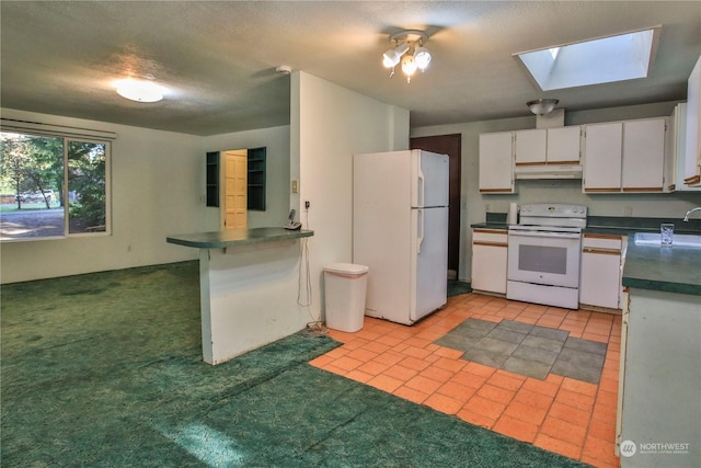 kitchen with sink, white cabinets, light colored carpet, white appliances, and a skylight