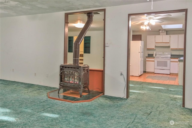 living room featuring light carpet, a textured ceiling, and a wood stove