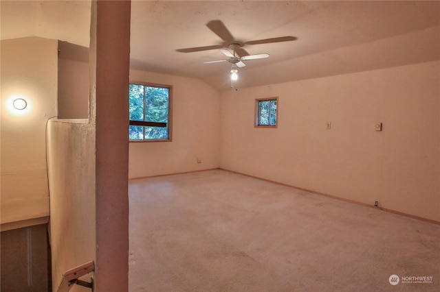 carpeted spare room with ceiling fan and vaulted ceiling