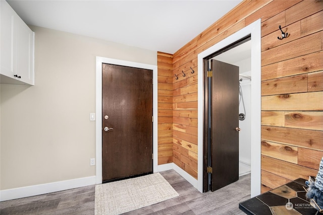 foyer featuring hardwood / wood-style flooring and wood walls