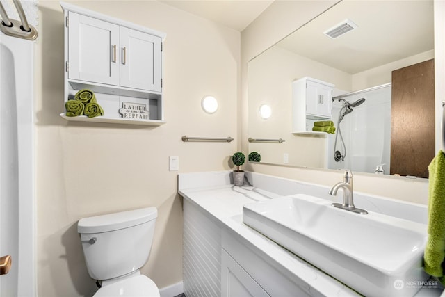 bathroom featuring a shower, vanity, and toilet