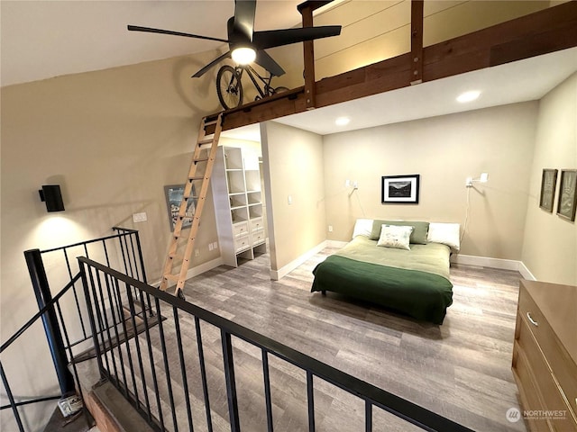 bedroom featuring hardwood / wood-style floors, a towering ceiling, and ceiling fan