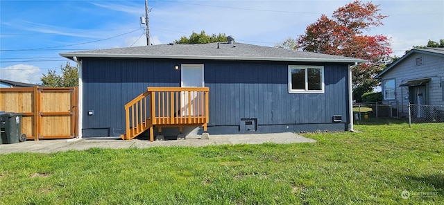 rear view of property featuring a yard and fence