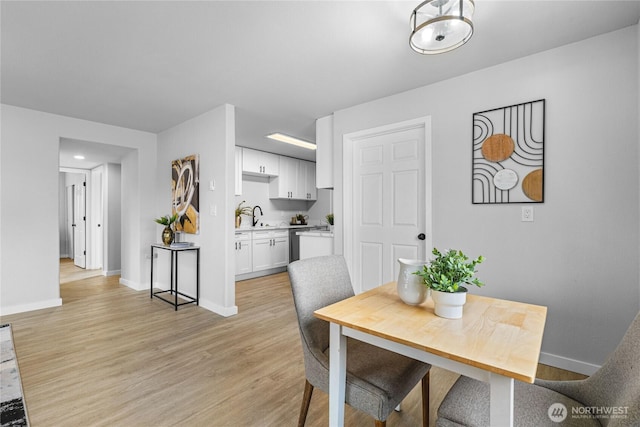 dining room featuring light wood-style floors and baseboards