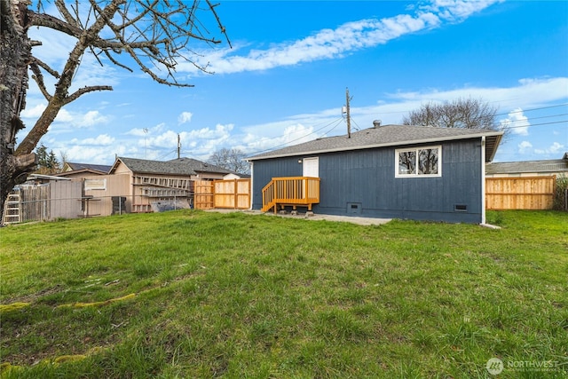 rear view of house with crawl space, a lawn, and a fenced backyard