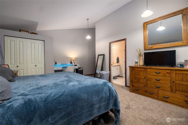 carpeted bedroom featuring ensuite bathroom, a closet, and vaulted ceiling