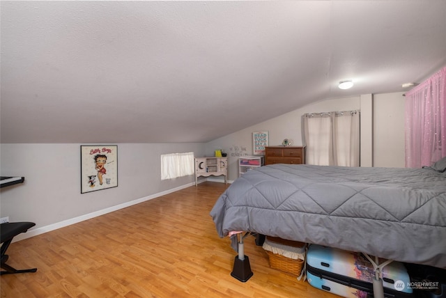 bedroom featuring hardwood / wood-style flooring and vaulted ceiling