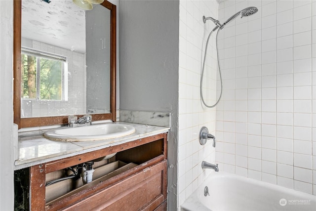 bathroom featuring vanity and tiled shower / bath