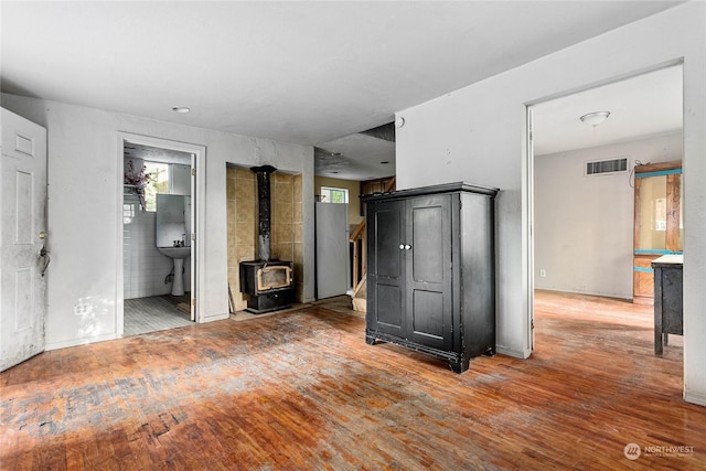 interior space with wood-type flooring and a wood stove