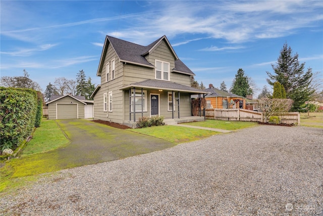 view of front facade featuring a porch, a garage, an outdoor structure, and a front lawn