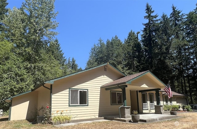 back of property with a garage and covered porch