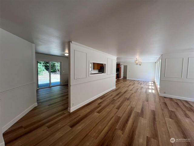 unfurnished living room with hardwood / wood-style flooring and a notable chandelier