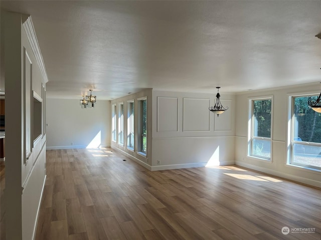 unfurnished living room featuring hardwood / wood-style flooring and a notable chandelier