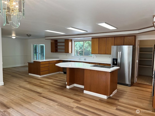 kitchen with a chandelier, stainless steel fridge, light wood-type flooring, and a kitchen island