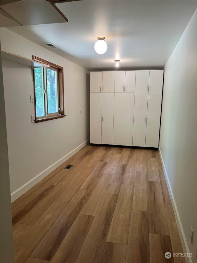 unfurnished bedroom with a closet and light hardwood / wood-style floors