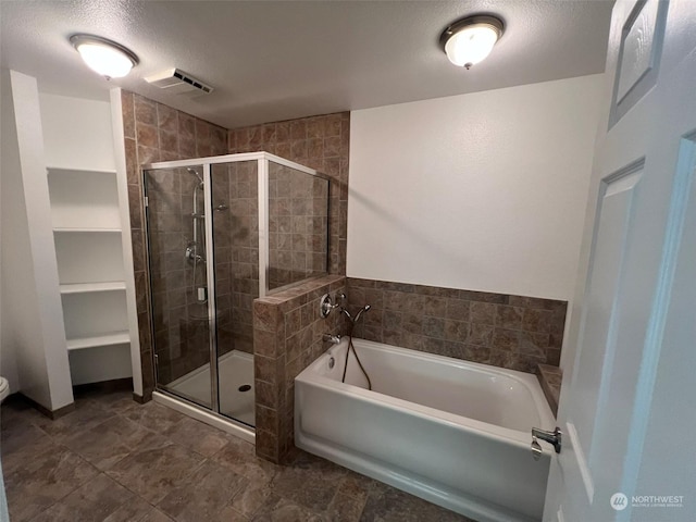 bathroom with a textured ceiling and separate shower and tub