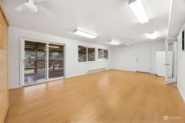 empty room with light hardwood / wood-style floors and a baseboard radiator