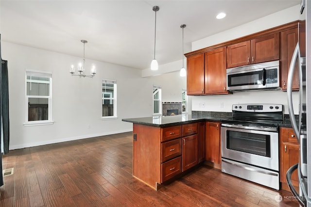 kitchen featuring stainless steel appliances, dark hardwood / wood-style flooring, a notable chandelier, kitchen peninsula, and pendant lighting