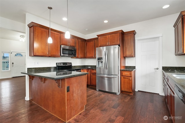 kitchen featuring a kitchen breakfast bar, pendant lighting, dark stone counters, and stainless steel appliances