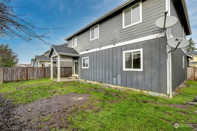 back of house featuring a lawn