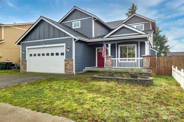 craftsman inspired home featuring covered porch, a front yard, and a garage