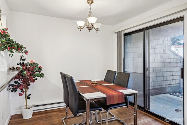 dining area with dark wood-type flooring, a baseboard radiator, and a notable chandelier