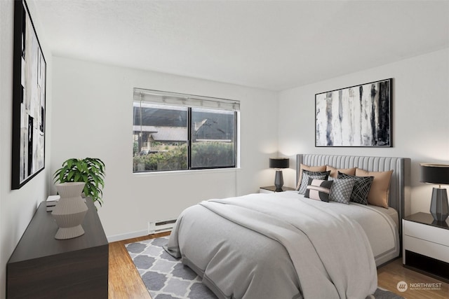 bedroom featuring baseboard heating and hardwood / wood-style flooring