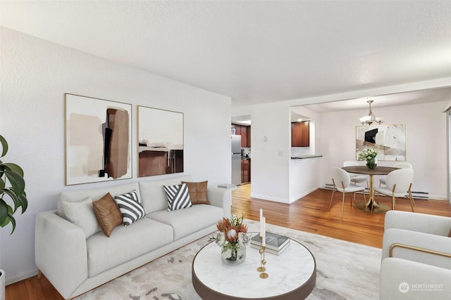 living room with light hardwood / wood-style floors and a notable chandelier