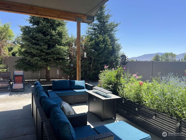 view of patio / terrace featuring a mountain view and an outdoor living space with a fire pit