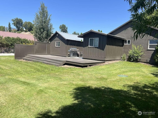 back of property featuring a wooden deck and a lawn