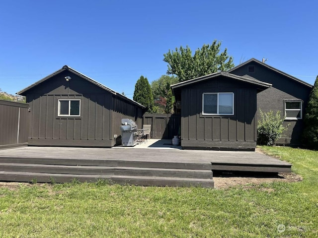 back of house featuring a shed, a wooden deck, and a yard