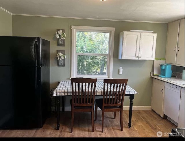 dining room with crown molding and light wood-type flooring